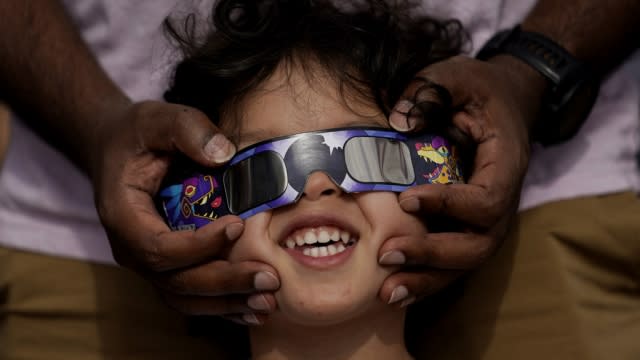 Viewers use special glasses to watch the solar eclipse from San Antonio, as the moon moves in front of the sun.