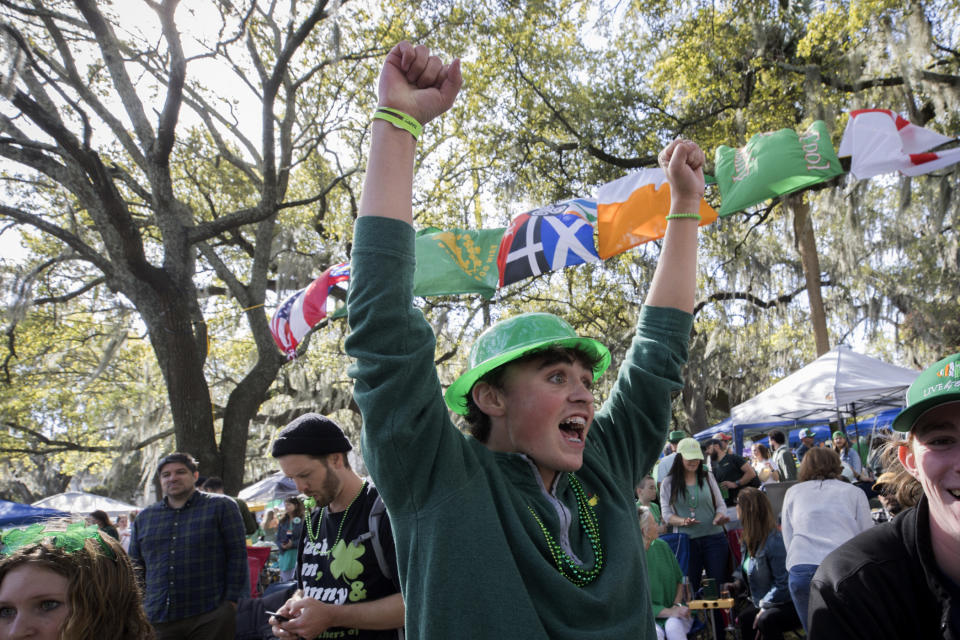 Jack Stephans celebra el paso del desfile del Día de San Patricio en la concurrida plaza sombreada por robles, el viernes 17 de marzo de 2023, en el centro histórico de Savannah, Georgia. (AP Foto/Stephen B. Morton)