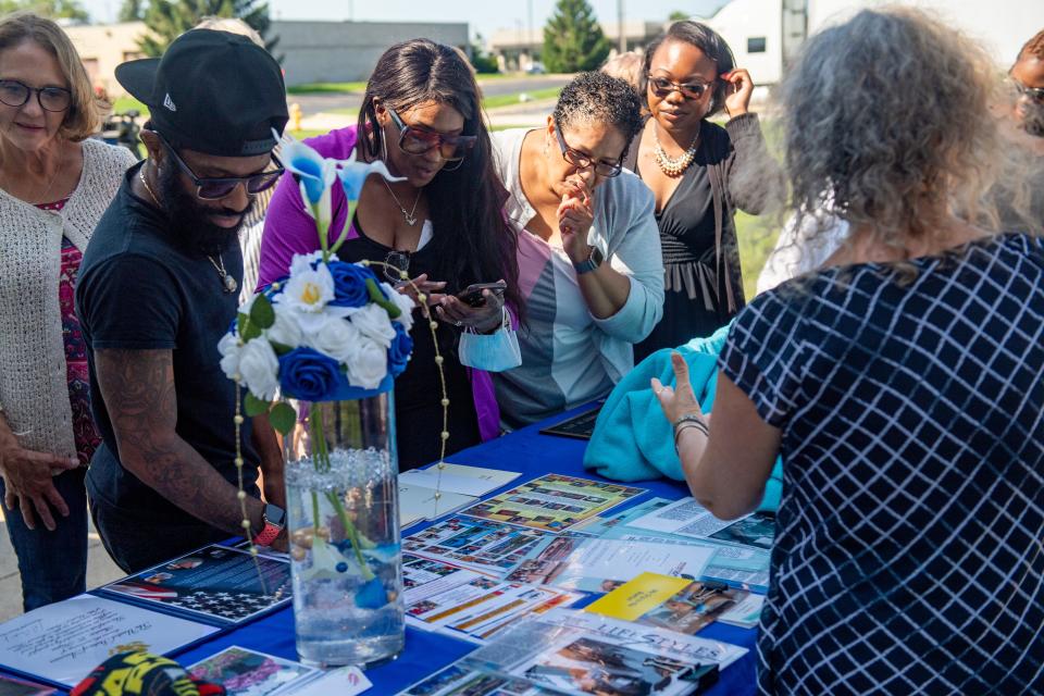 Guests look over items to be placed in a time capsule celebrating Milestone, Inc.'s 50th anniversary during a ceremony Wednesday, Aug. 16, 2023, at a Milestone facility in Loves Park.