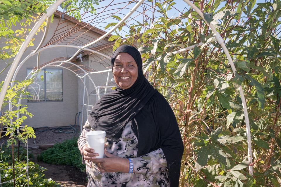 Ibado Mahmud poses in her backyard garden where she grows fruits and vegetables for Drinking Gourd Farms on Nov. 13, 2021, in Phoenix.