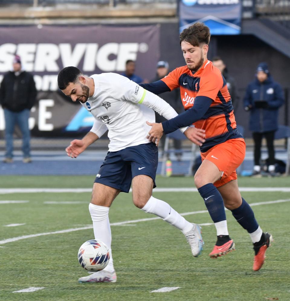 University of New Hampshire men's soccer captain Eli Goldman shields a Syracuse defender during Sunday's NCAA second-round game at Wildcat Stadium.