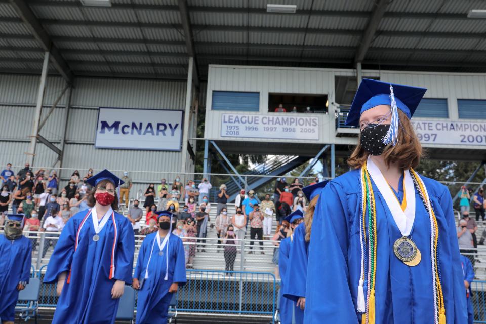 Students move their tassels and prepare to leave the field following a graduation ceremony at McNary High School in Keizer, Ore., on Aug. 7, 2020.