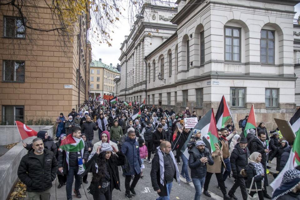 Protesters hold Palestinian flags as they march in Stockholm, Sweden.