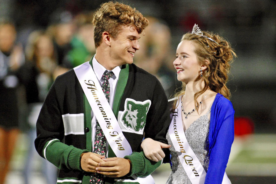 In this Friday, Sept. 27, 2019, photo, Deserae Turner stands with Case Gehring as the Homecoming Court is announced during halftime of Green Canyon's football game in North Logan, Utah. Turner, a Utah high school student who survived a gunshot wound to the head was named homecoming queen by her classmates. Turner was found in a ditch after being shot in the back of the head and left for dead by two classmates in February 2017. (John Zsiray/5150photos.com via AP)