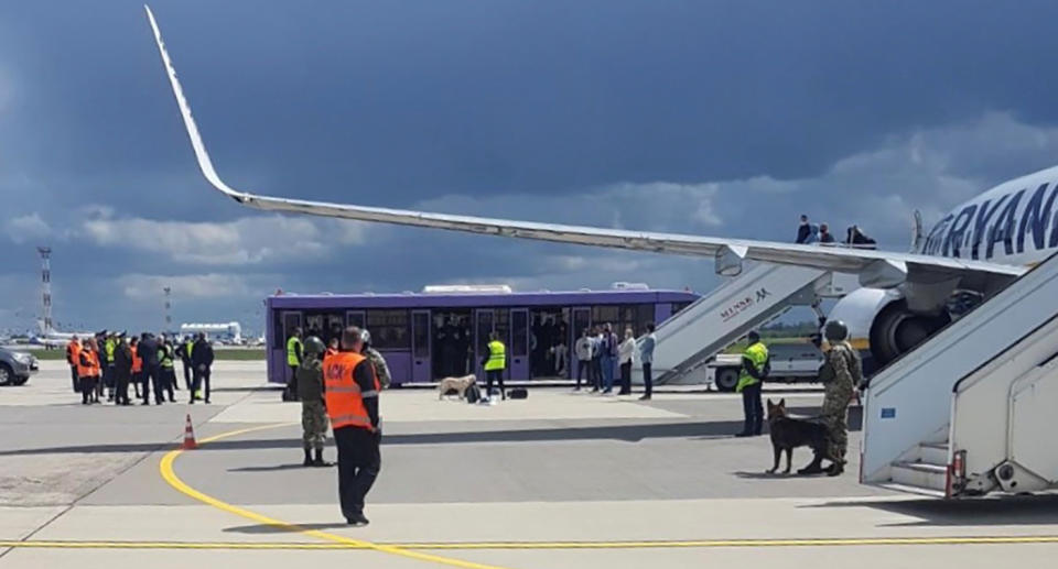 Airport personnel and security forces are seen on the tarmac in front of a Ryanair flight which was forced to land in Minsk, Belarus, May 23, 2021. Picture taken May 23, 2021. Handout via REUTERS ATTENTION EDITORS - THIS PICTURE WAS PROVIDED BY A THIRD PARTY. - RC2HMN9RPI6Z