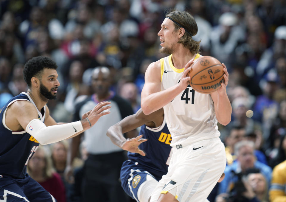 Utah Jazz forward Kelly Olynyk, right, looks to pass the ball as Denver Nuggets guard Jamal Murray, left, defends in the first half of an NBA basketball game Monday, Oct. 30, 2023, in Denver. (AP Photo/David Zalubowski)