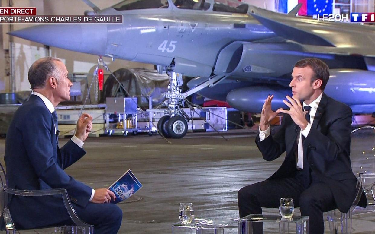 French President Emmanuel Macron speaking (R) during a televised interview aboard the Charles de Gaulle aircraft carrier - AFP
