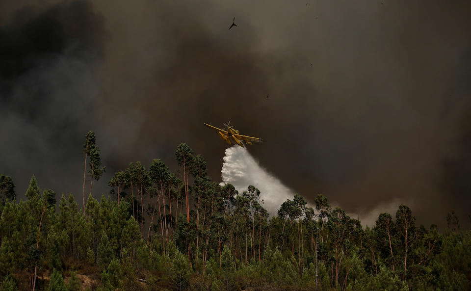 <p>A firefighting plane dumps water on a forest fire next to the village of Macao, near Castelo Branco, Portugal, July 26, 2017. (Rafael Marchante/Reuters) </p>