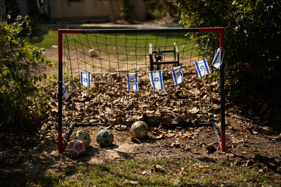 Israel flags hang in a soccer goal in a backyard of a home that came under attack during a massive Hamas invasion into Kibbutz Nir Oz, Israel, Thursday, Oct. 19, 2023. Nir Oz is one of more than 20 towns and villages in southern Israel that were ambushed in the sweeping assault by Hamas on Oct. 7. The kibbutz on a low rise overlooking the border fence with Gaza suffered a particularly harsh toll. (AP Photo/Francisco Seco)