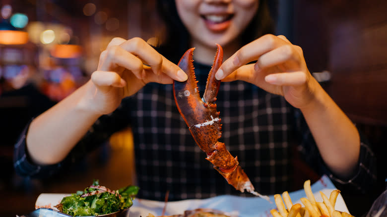 Woman eating lobster claw