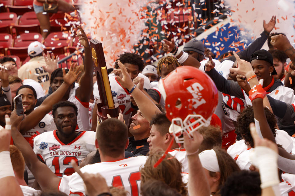 Sam Houston State head coach K.C. Keeler hoists the championship trophy after defeating South Dakota State 23-21 for the NCAA college FCS Football Championship in Frisco, Texas, Sunday, May 16, 2021. (AP Photo/Michael Ainsworth)