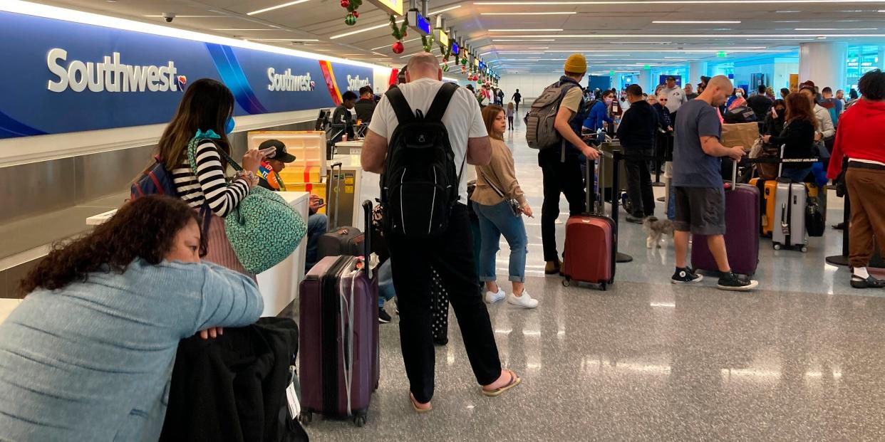 Travelers wait at a Southwest Airlines baggage counter to retrieve their bags after canceled flights at Los Angeles International Airport, Monday, Dec. 26, 2022, in Los Angeles.