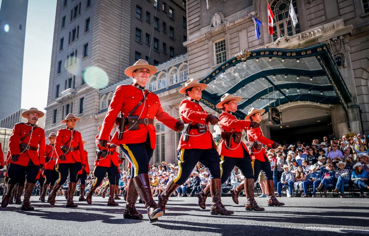 RCMP members march in front of the Fairmont Palliser Hotel during the Calgary Stampede parade in this file photo. Hotel spending is expected to level-off during this year's 10-day event.  (Jeff McIntosh/The Canadian Press - image credit)