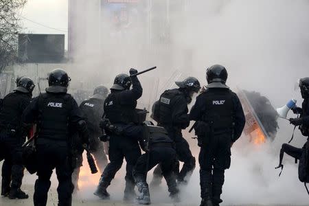 Police try to put out a fire after protesters threw molotov cocktails during clashes in Pristina, Kosovo January 9, 2016. REUTERS/Agron Beqiri