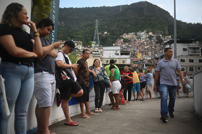 La gente hace cola para votar cerca de Rocinha (al fondo), la favela más grande de Río de Janeiro, Brasil, el 30 de octubre de 2022, durante la segunda vuelta de las elecciones presidenciales. 