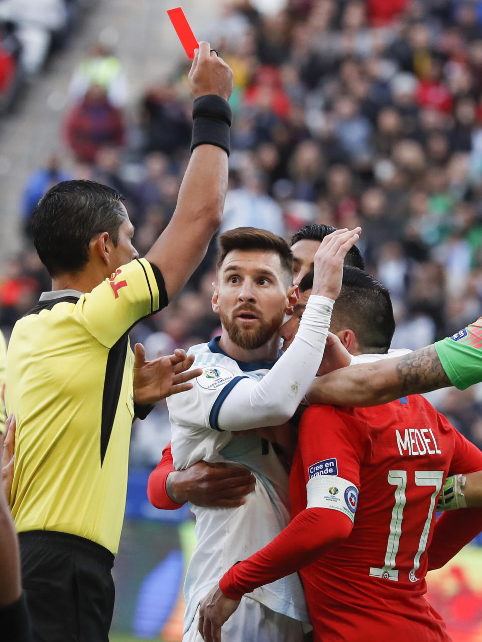 Argentina's Lionel Messi, center, and Chile's Gary Medel, right, scuffle as referee Mario Diaz, from Paraguay, left, shows the red card to both of them during Copa America third-place soccer match at the Arena Corinthians in Sao Paulo, Brazil, Saturday, July 6, 2019. (AP Photo/Victor R. Caivano)