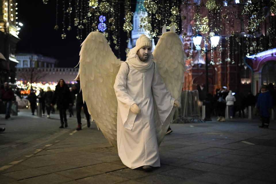 A street actor dressed as an angel walks near Red Square in Moscow, Russia, late Monday, Feb. 14, 2022. While the U.S. warns that Russia could invade Ukraine any day, the drumbeat of war is all but unheard in Moscow, where political experts and ordinary people alike don't expect President Vladimir Putin to launch an attack on the ex-Soviet neighbor. (AP Photo/Alexander Zemlianichenko)