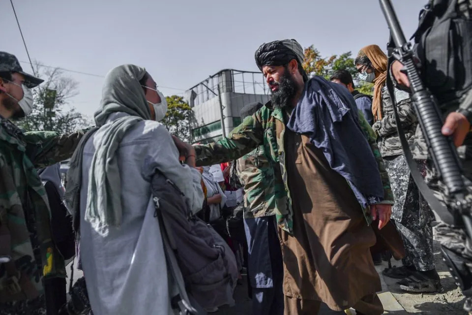 TOPSHOT - Taliban members stop women protesting for women's rights in Kabul on October 21, 2021. - The Taliban violently cracked down on media coverage of a women's rights protest in Kabul on October 21 morning, beating several journalists. (Photo by BULENT KILIC / AFP) (Photo by BULENT KILIC/AFP via Getty Images)