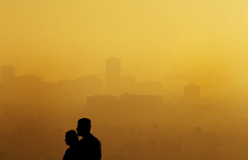 LONG BEACH, CALIF. - DEC. 2, 2021. Visitors to Signal Hill views downtown Long Beach covered in a pall of fog and smog on Wednesday, Dec. 1, 2021. Countless trucks and dozens of ships are currently in the harbor area as workers try to clear a supply chain backlog ahead of the yearend holidays. The activity has resulted in spikes of carbon emmissions in the surrounding communities of San Pedro, Wilmington and Long Beach. (Luis Sinco / Los Angeles Times)