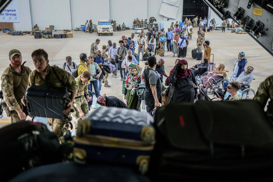 In this photo provided by the UK Ministry of Defence, British Nationals prepare to be evacuated onto a RAF aircraft at Wadi Seidna Air Base, in Sudan, Thursday, April 27, 2023. (PO Phot Arron Hoare/UK Ministry of Defence via AP)