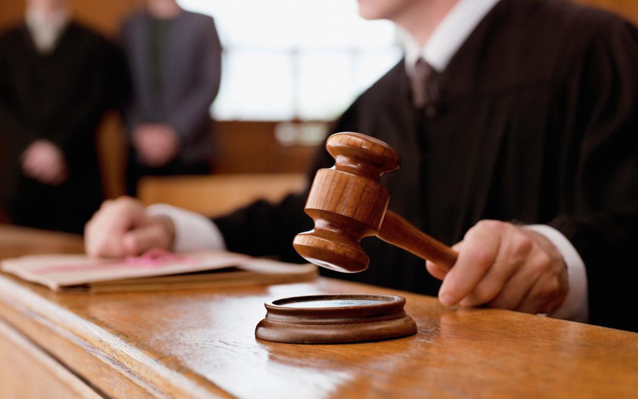 A judge holding a gavel in court - Alamy