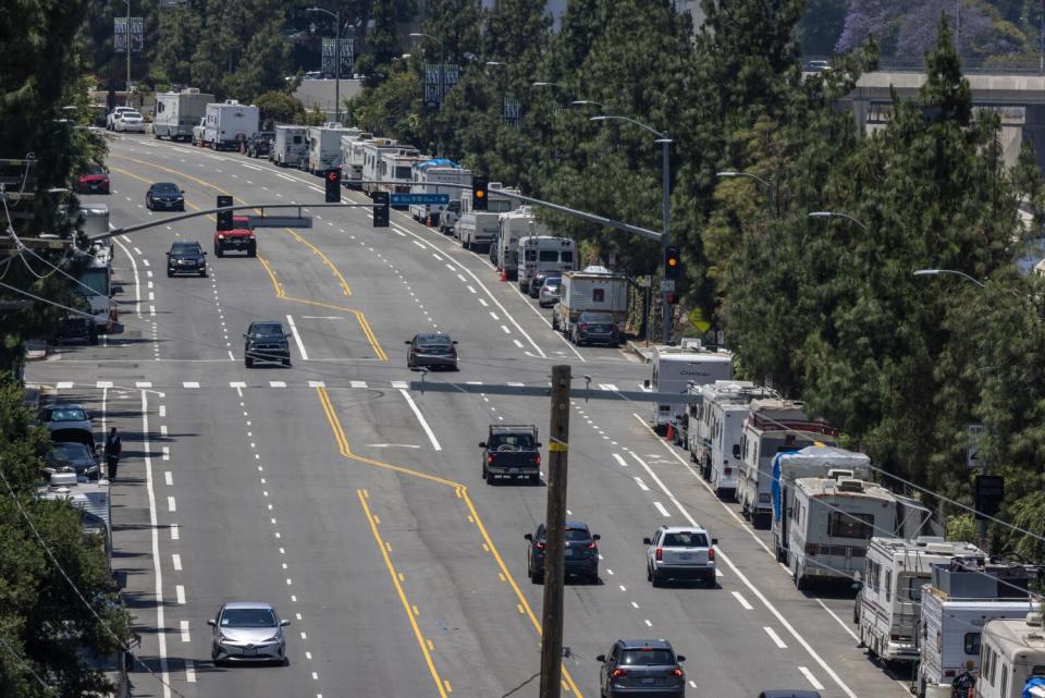 A road with RVs lining its right side.