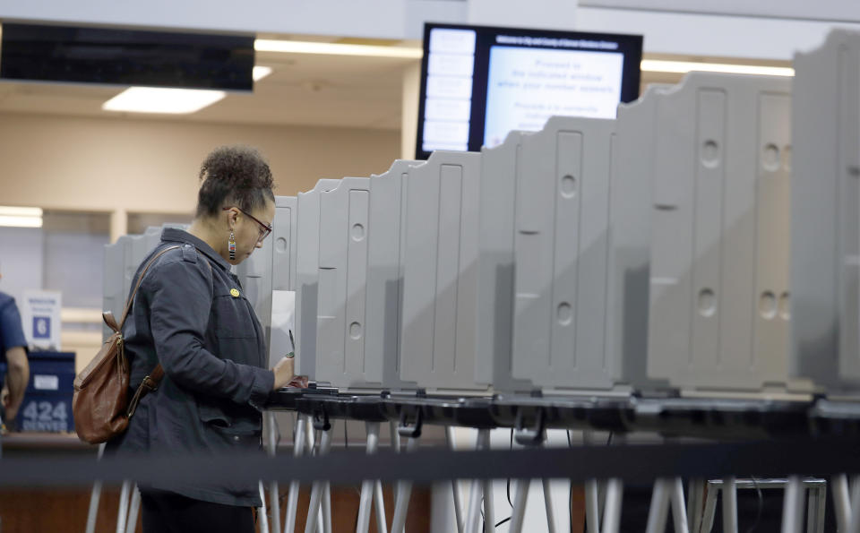 A lone voter fills out a ballot in the lobby of the Denver Elections Division early Tuesday, Nov. 5, 2019, in downtown Denver. (AP Photo/David Zalubowski)