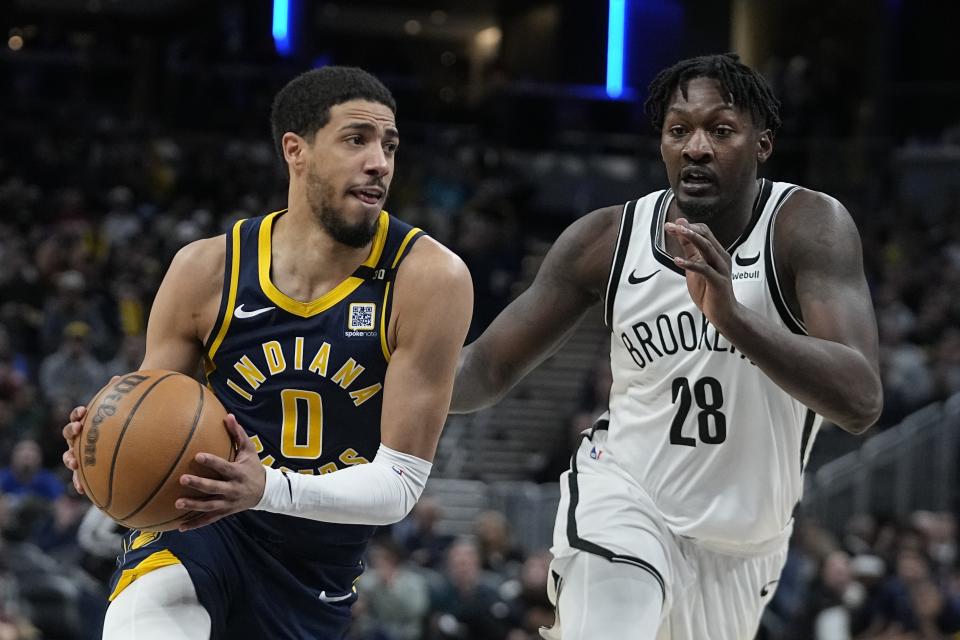 Indiana Pacers' Tyrese Haliburton (0) hopes to the basket against Brooklyn Nets' Dorian Finney-Smith (28) during the second half of an NBA basketball game, Monday, April 1, 2024, in Indianapolis. (AP Photo/Darron Cummings)