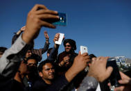 Afghans take picture with a Taliban in Kabul, Afghanistan June 16, 2018. REUTERS/Mohammad Ismail