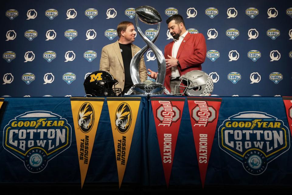 Dec 28, 2023; Arlington, Texas, USA; Ohio State Buckeyes head coach Ryan Day and Missouri Tigers head coach Eliah Drinkwitz talk behind the Field Scovell Trophy during a press conference prior to the Goodyear Cotton Bowl Classic at AT&T Stadium.