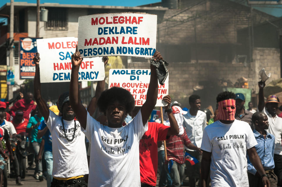Haitians carry banners during a protest to denounce the draft constitutional referendum carried by the President Jovenel Moise on March 28, 2021 in Port-au-Prince, Haiti. / Credit: Sabin Johnson/Anadolu Agency via Getty Images