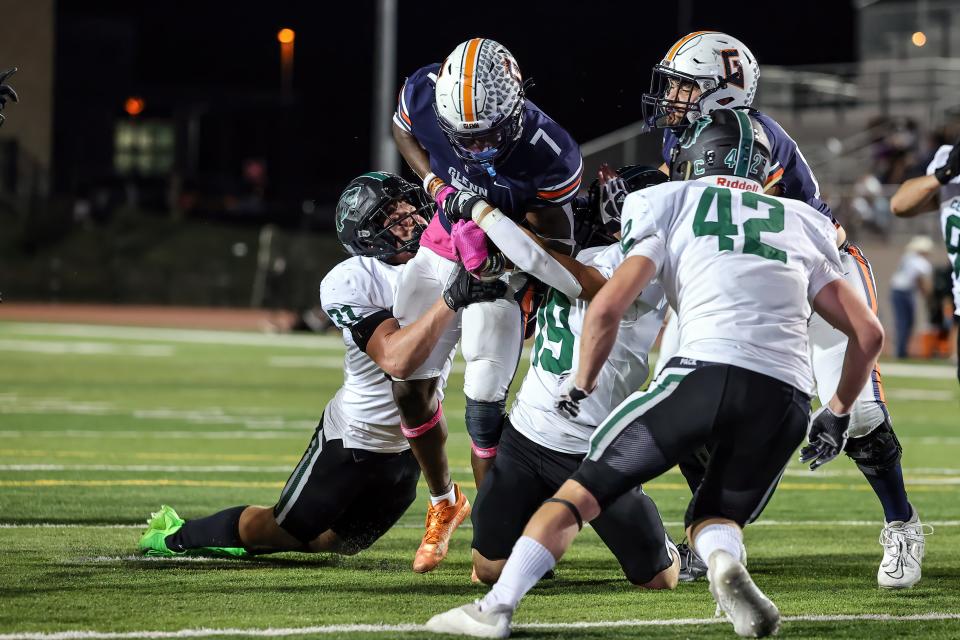 Cedar Park linebacker Brady Elford, left, hangs to Glenn runner DJ Dugar as Cedar Park frustrated the Grizzlies' rushing attack in a 21-10 district victory Friday at Bible Stadium.