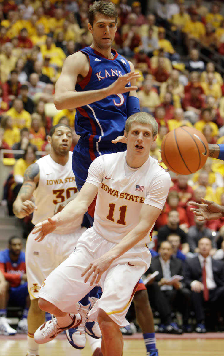 Iowa State guard Scott Christopherson (11) passes the ball under Kansas center Jeff Withey during the first half of an NCAA college basketball game, Saturday, Jan. 28, 2012, in Ames, Iowa.