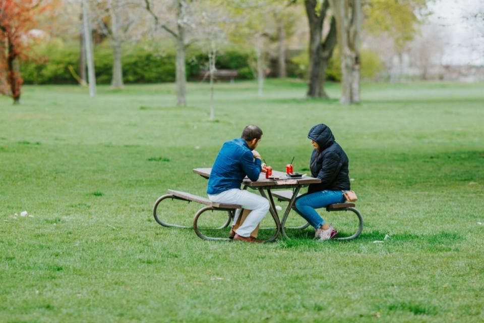 Couple sitting at picnic table in Jackson Park, Chicago.