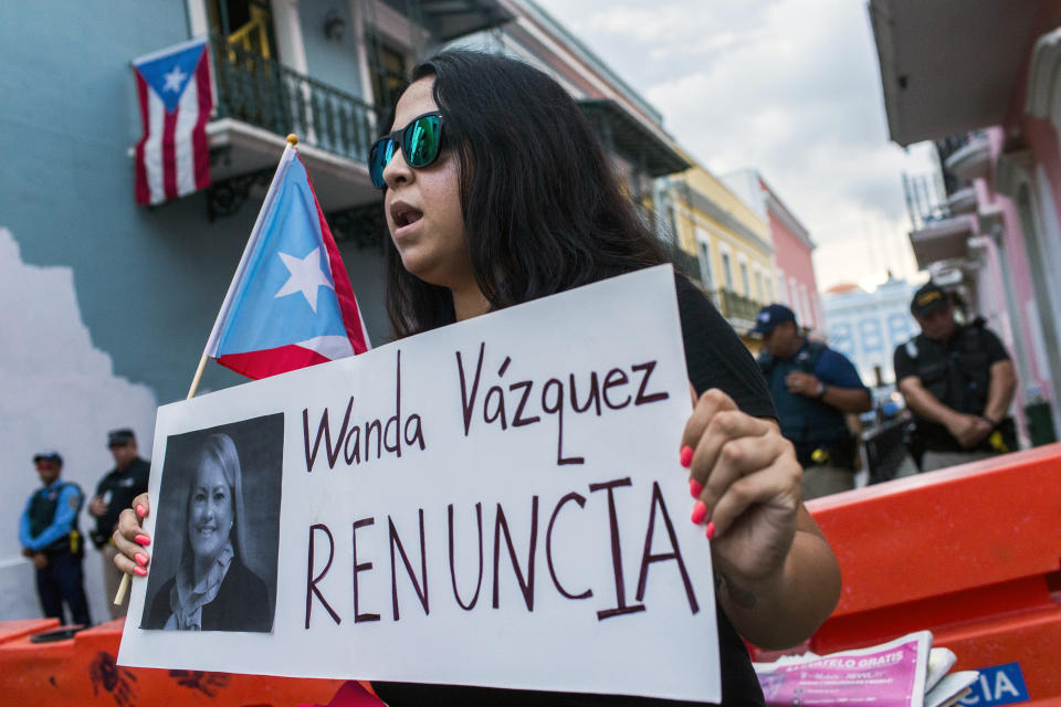 Protesters gather outside the government mansion La Fortaleza in San Juan, Puerto Rico, Wednesday, Aug. 7, 2019, calling for the removal of the island's newly sworn-in governor. Justice Secretary Wanda Vazquez took the oath of office early Wednesday evening at the Puerto Rican Supreme Court, which earlier in the day ruled that Pedro Pierluisi's swearing in last week was unconstitutional. (AP Photo/Dennis M. Rivera Pichardo)