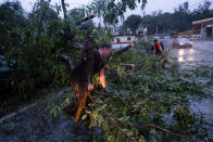 <p>People clear a road from a fallen tree after Hurricane Fiona affected the area in Yauco, Puerto Rico September 18, 2022. REUTERS/Ricardo Arduengo</p> 