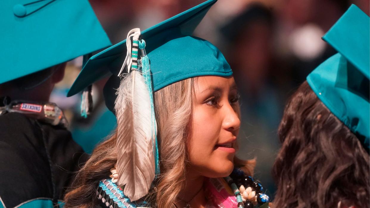 A student wears an eagle feather at her graduation from high school in Cedar City, Utah. In Oklahoma, Gov. Kevin Stitt vetoed a bill that would have ensured indigenous students could wear tribal regalia during graduation ceremonies.