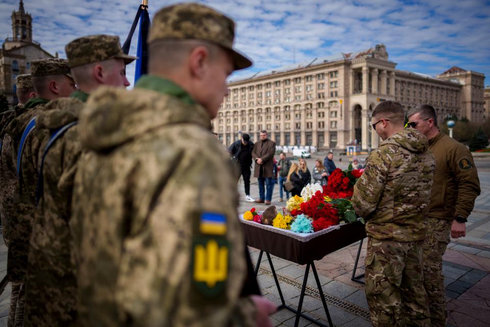Ukrainian servicemen stan next to the coffin of their fallen fellow Vadym Popelniuk, born in 1991, after a religious service in Independence Square in Kyiv (AP)