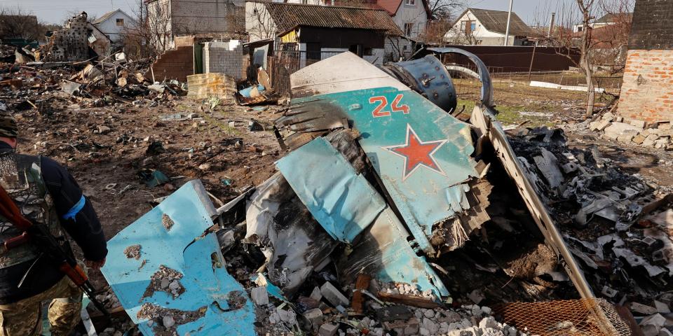 A member of the Ukrainian Territorial Defence Forces inspects remains of a Russian Sukhoi Su-34 fighting aircraft among residential area, as Russia's attack on Ukraine continues, in Chernihiv, Ukraine April 6, 2022. REUTERS/Serhii Nuzhnenko