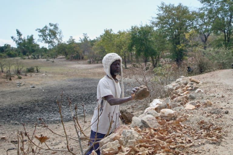 Takesure Chimbu, paysan de 58 ans, dans la réserve d'eau asséchée près de Kotwa, dans le nord-est du Zimbabwe, le 2 juillet 2024 (Jekesai NJIKIZANA)