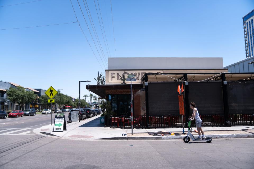 A person rides an electric scooter along Roosevelt Row in Phoenix on July 5, 2023. An Excessive Heat Warning issued by the National Weather Service is in effect until July 7 at 8 p.m.