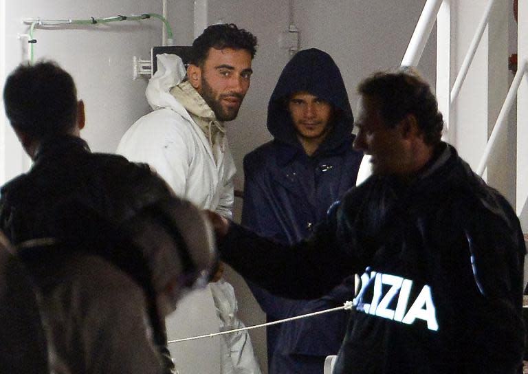 Tunisian captain Mohammed Ali Malek (2nd L) and a man identified as Mahmud Bikhit (2nd R), another survivor and understood to be a crew member of the boat, stand onboard an Italian Coast Guard vessel in Senglea, Malta, April 20, 2015