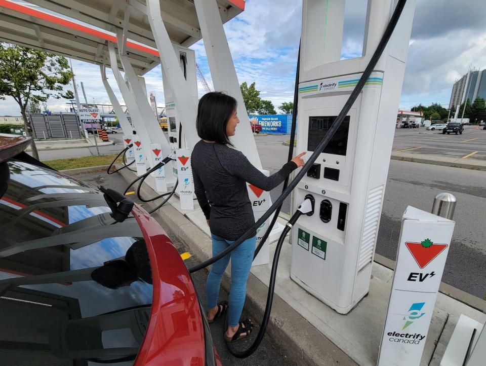 A woman checks the status of the charge for her Volkswagen ID.4 EV at a charging station at a Canadian Tire in Scarborough, Ont., on Wednesday June 14, 2023. 