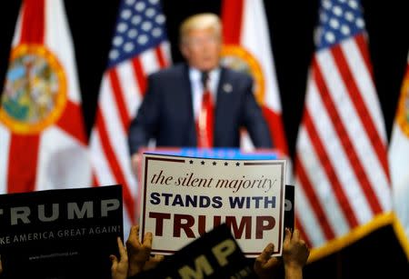 Supporters hold up signs while listening to Republican U.S. presidential candidate Donald Trump during a campaign rally in Tampa, Florida, U.S. June 11, 2016. REUTERS/Scott Audette