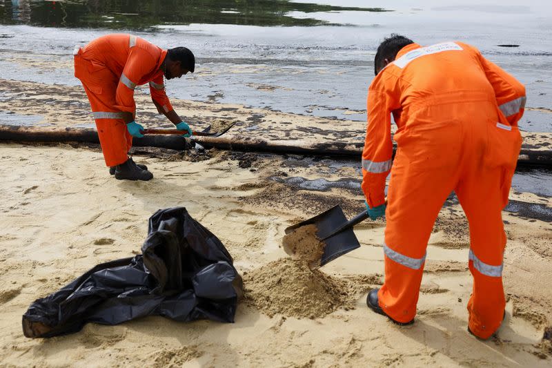 Workers clean up the oil slick at Tanjong Beach in Sentosa