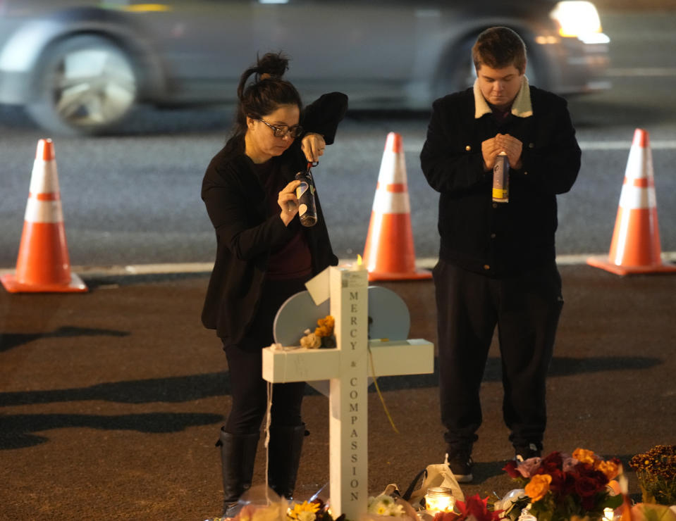 Mourners gather at a makeshift memorial, Tuesday, Nov. 22, 2022, in Colorado Springs, Colo, for the victims of a gay nightclub shooting. (AP Photo/David Zalubowski)