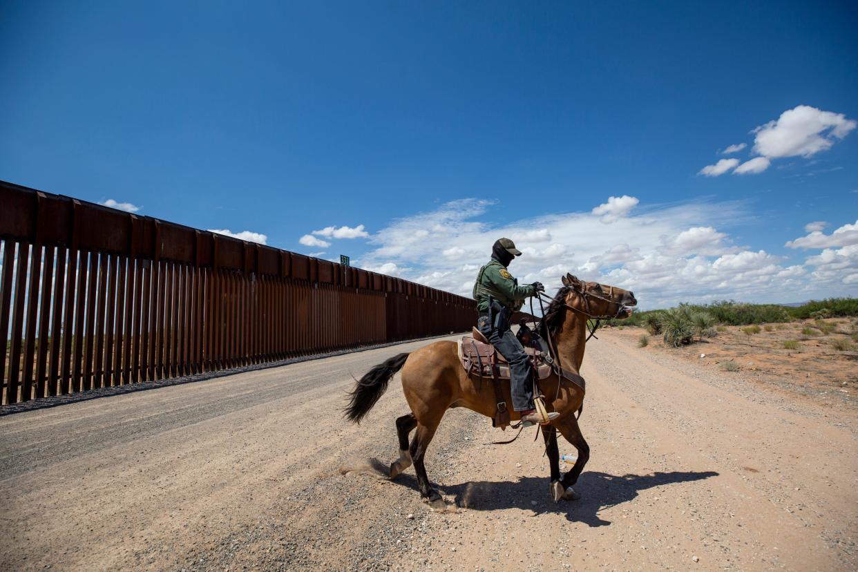 U.S. Border Patrol agents get ready to use horses to track a recent group of migrants who had crossed the border wall in New Mexico in late August 2023.