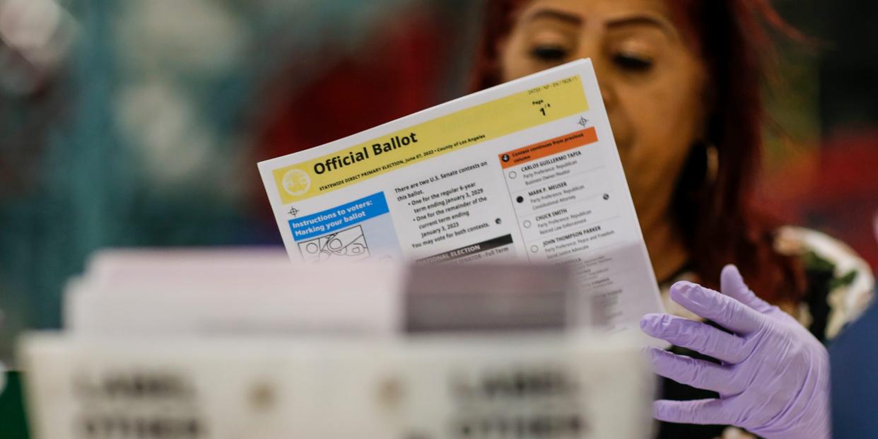 A poll worker processes a marked ballot.