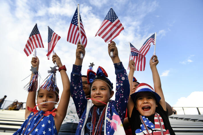 Sadie Portillo, 7, left, her brother Santos, 6, right, and their cousin Adrienne Jaramillo, 6, wave American flags and came dressed to celebrate the Fourth of July and watch the fireworks display with their family at JeffCo stadium on July 4, 2019 in Lakewood, Colorado.  (Photo: Helen H. Richardson/MediaNews Group/The Denver Post via Getty Images)