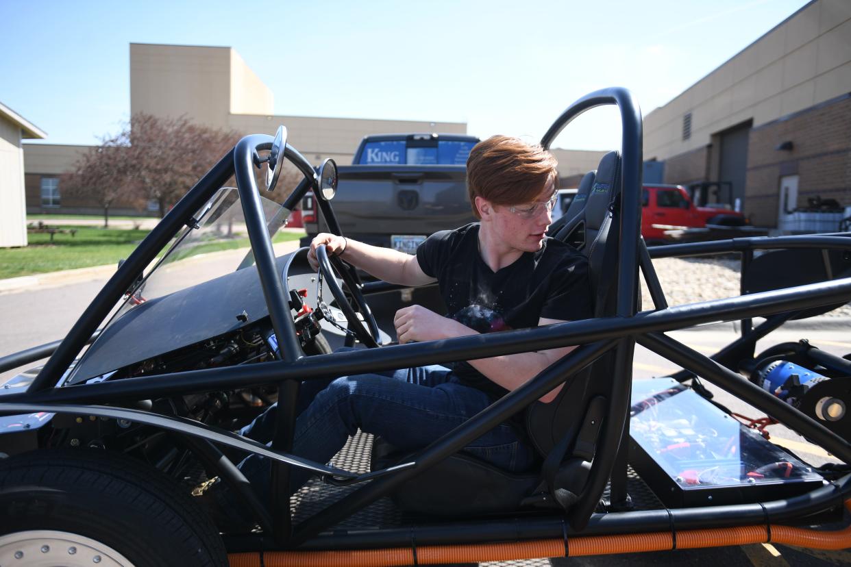 Harrisburg senior Kendrick Droppers, 18, backs the electric car into the garage on Wednesday, April 24, 2024 at Tiger Stripes Garage in Harrisburg.